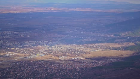 Handheld-overview-of-Sofia-city-and-towns-at-base-of-mountains-and-hills