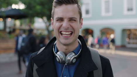 close-up-portrait-of-attractive-young-man-laughing-cheerful-at-camera-in-busy-urban-background