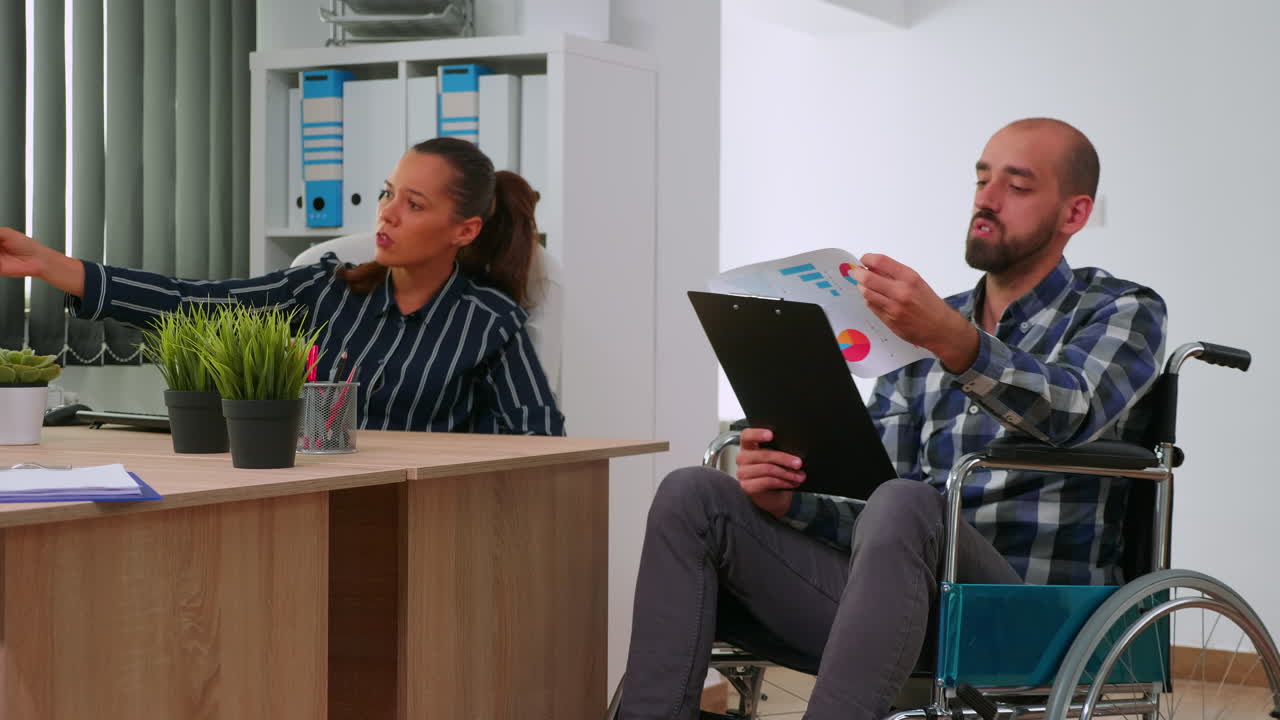 Manager in wheelchair giving advice about project to partner