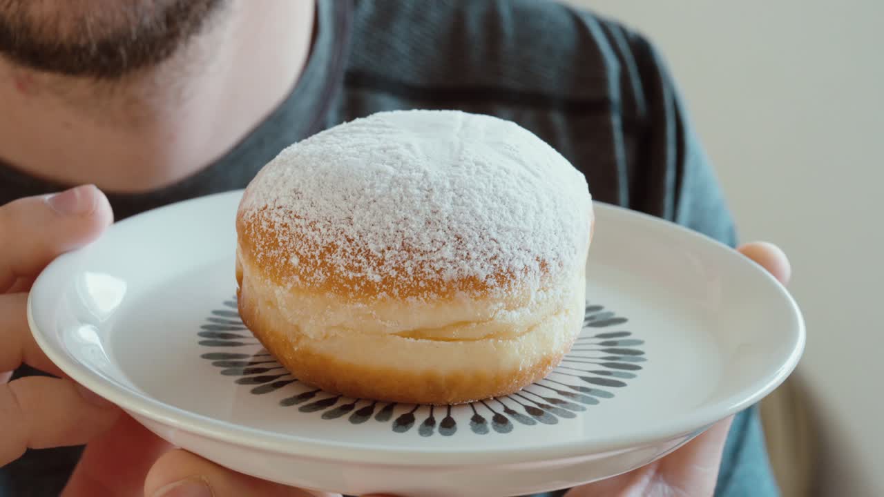 Primo piano di un Berliner con zucchero a velo servito su un piatto.