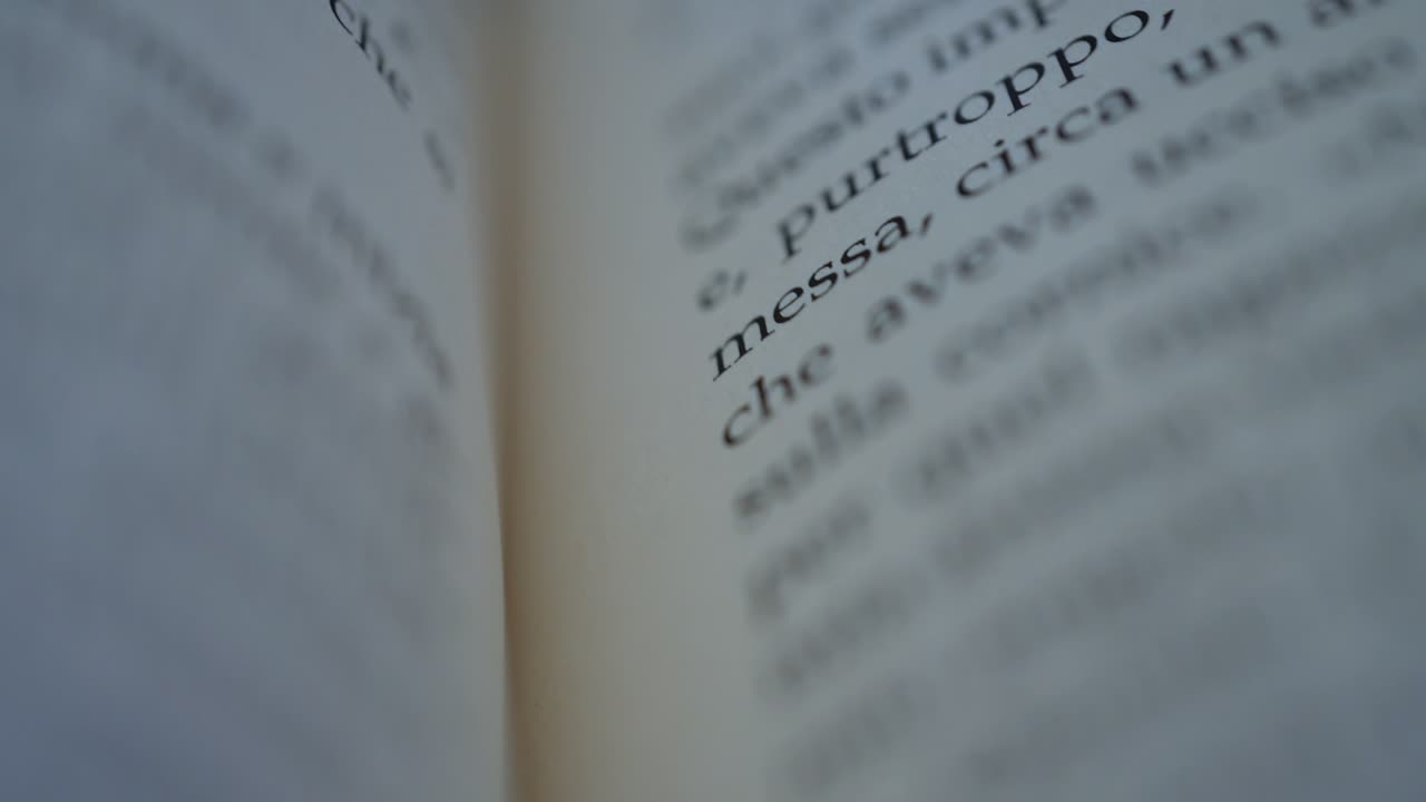 la cámara se desplaza a través de una página de un libro italiano en cámara lenta macro tiro enfoque superficial