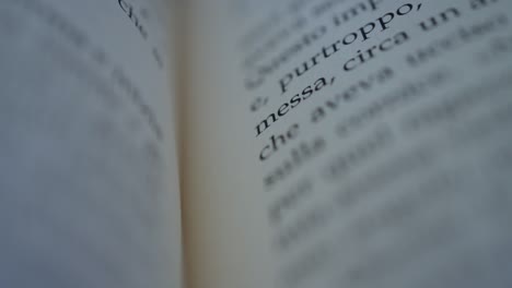 camera scrolls across a page of an italian book slow motion macro shot shallow focus