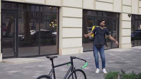 A-bearded-guy-with-a-backpack-is-fooling-around-and-dancing