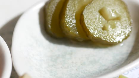 un tenedor lleno de pepinos encurtidos