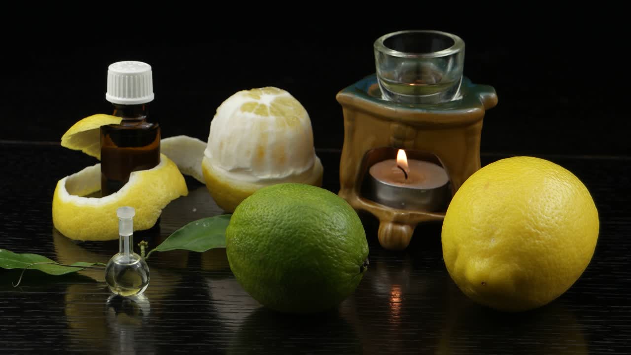 aromaterapia con aceite de limón. lámpara de aroma, limón, botellas con aceite de lemón en una mesa de madera negra