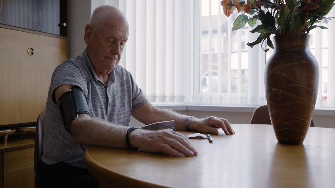 Senior man checking blood pressure at home