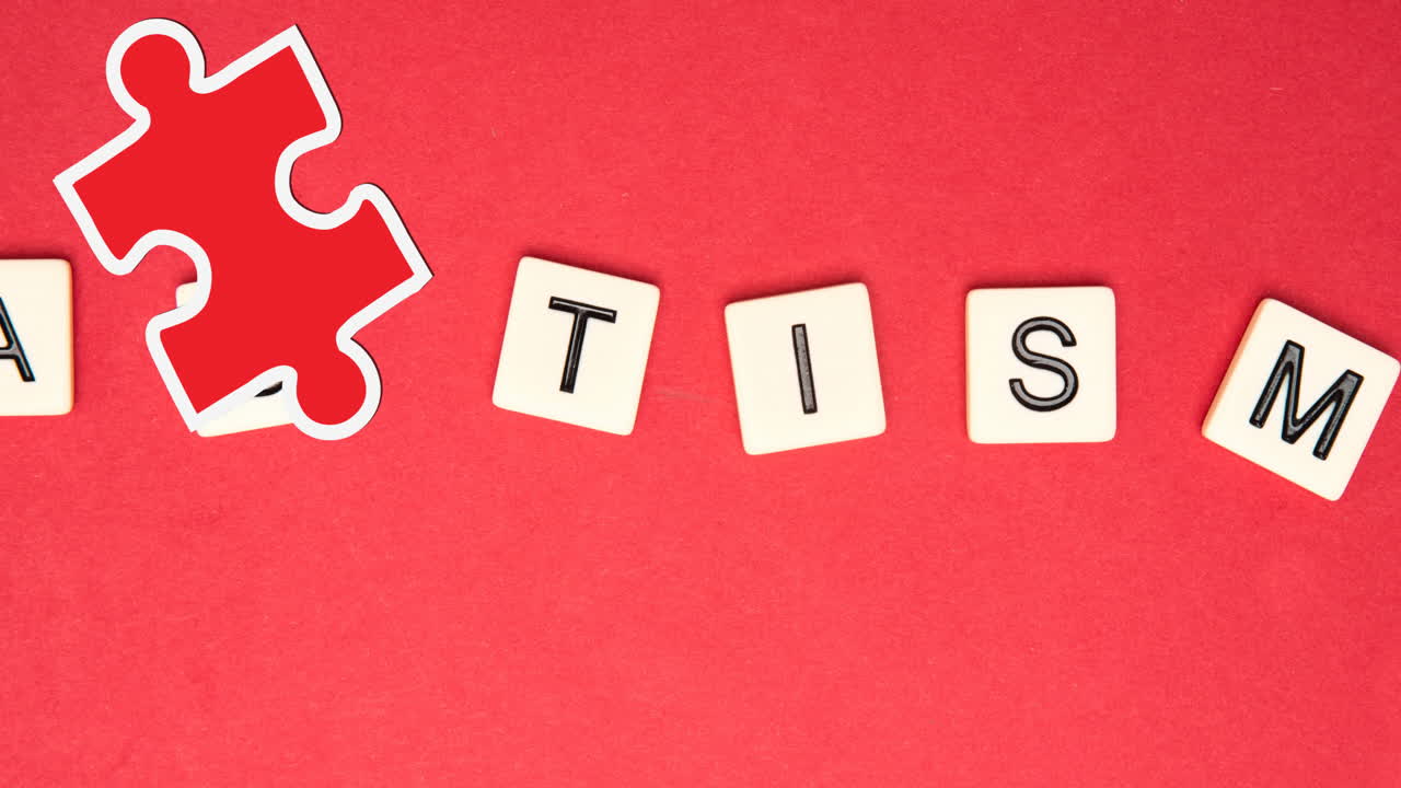 Animation of red and yellow puzzle pieces falling over autism text on squares on red background