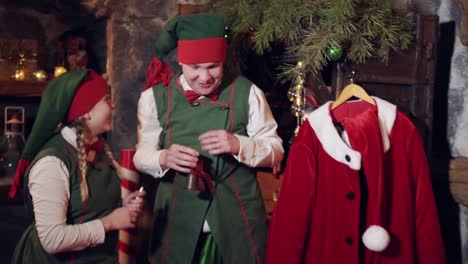 naughty elves with a bell waking santa. funny elves ringing with a little bell over santa sleeping in his bed at christmas eve
