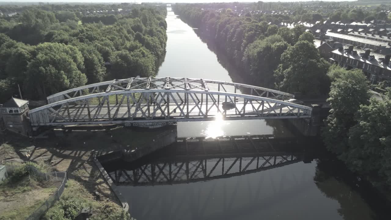 Veduta aerea di una suggestiva vecchia passerella pedonale e stradale in acciaio ad arco, che scende verso l'attraversamento del Canale Navigabile di Manchester