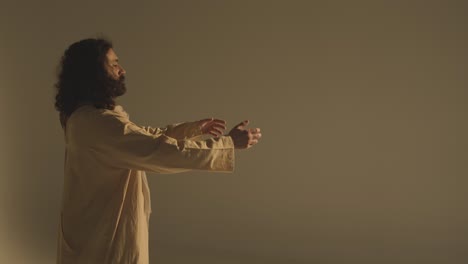 portrait of man wearing robes with long hair and beard representing figure of jesus christ raising hands in prayer 1