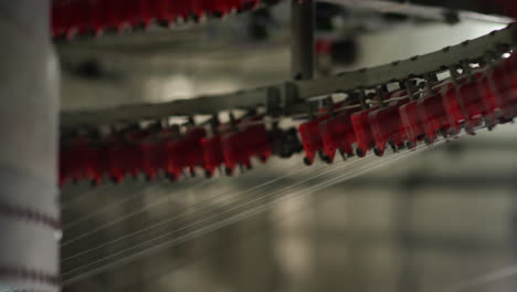 cotton threads travel through gears of an automated cotton knitting machinery in a textile factory in china