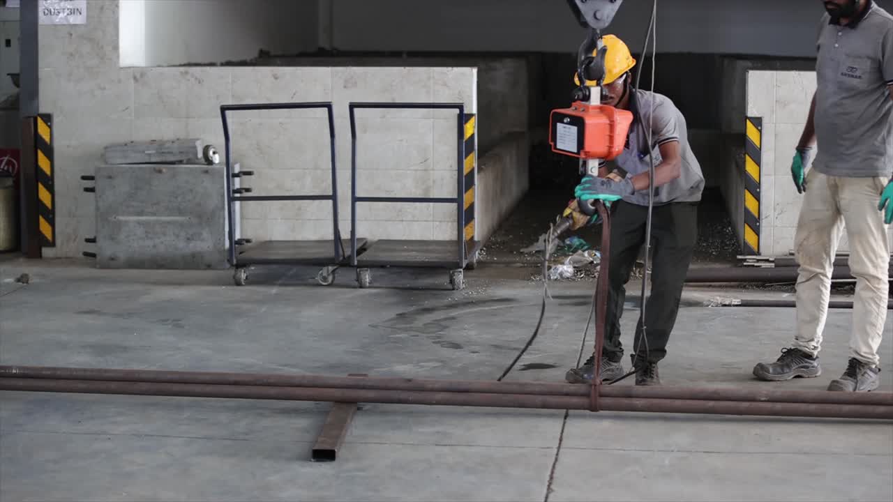 worker picking a metal rod