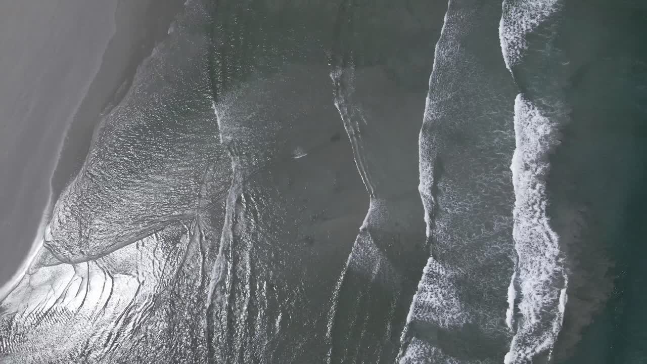 las olas rodan sobre una playa con una desembocadura del río de la laguna como se ve desde arriba