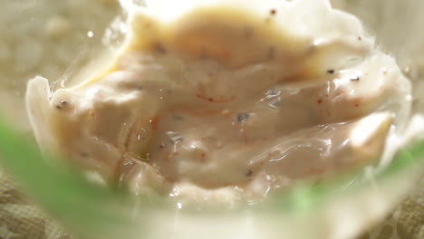 dunking a shrimp in a white sauce