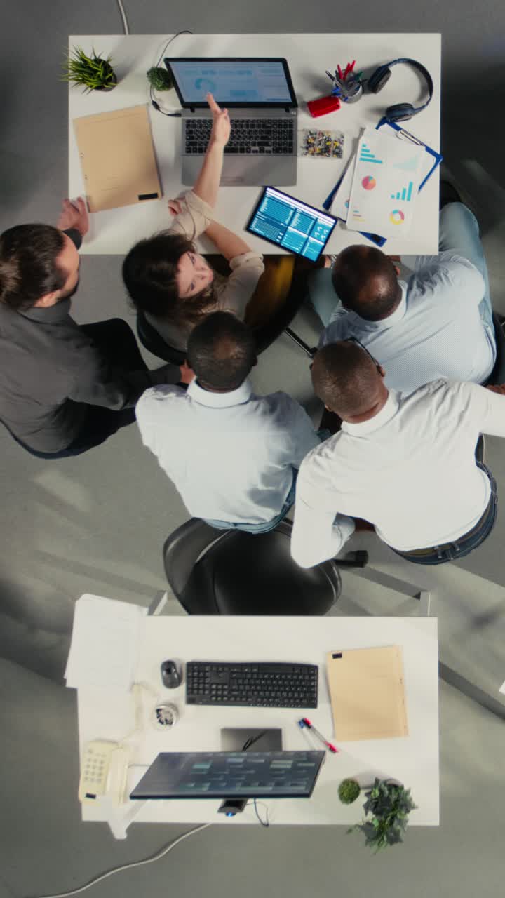 Vertical Video Top down view of diverse professionals collaborating on business analytics