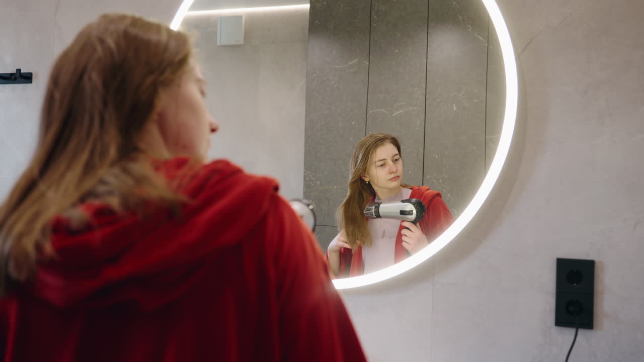 욕실 에서 머리카락 을 건조 시키는 여자