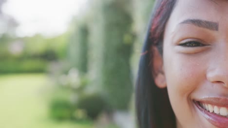 Portrait-of-happy-biracial-teenager-girl-looking-at-camera-with-copy-space,-in-slow-motion