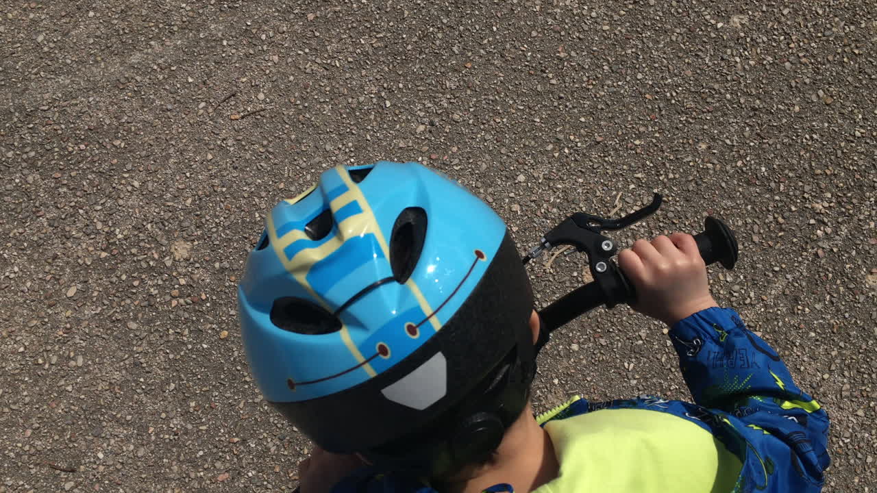niño monta una bicicleta vista desde arriba sigue la toma