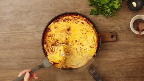 Crop-person-serving-appetizing-gratin-with-cheese-in-kitchen
