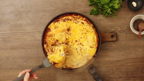 persona de la cosecha que sirve gratin apetitoso con queso en la cocina