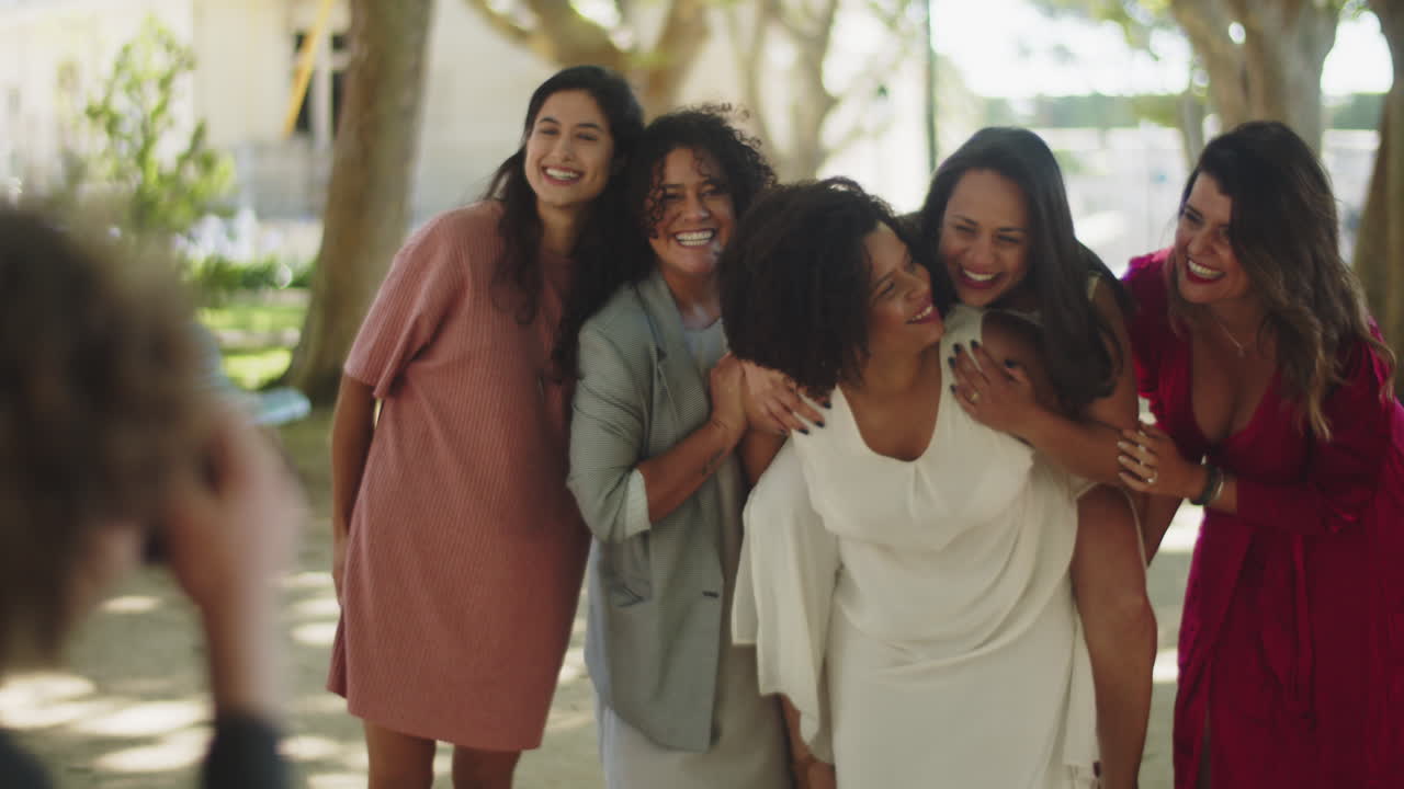 женская пара веселится и делает свадебное фото с друзьями