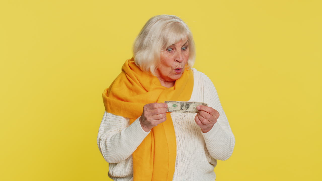 Poor senior old woman insufficient amount of money holding piggybank and one dollar banknote crisis