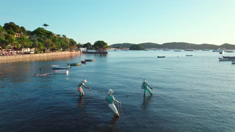 Drone-flyover-the-Three-Fishermen-monument-in-Armaçao-de-Búzios,-Brazil