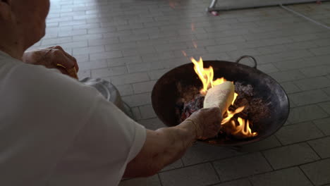 close-up-shot-on-hand,-put-joss-paper-into-the-flame