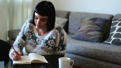 Woman-writing-on-a-diary-in-living-room-4k