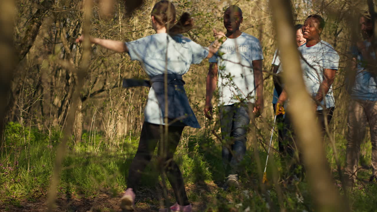un grupo alegre y orgulloso de activistas terminando la limpieza de basura en un bosque,