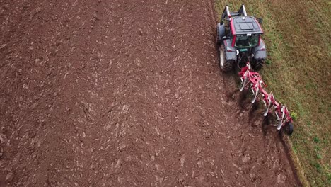 drone shot of a tractor plowing fields with copyspace