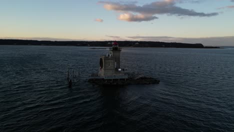 An-aerial-view-of-the-Huntington-Harbor-Lighthouse-on-Long-Island,-NY-at-sunset,-with-a-Christmas-wreath