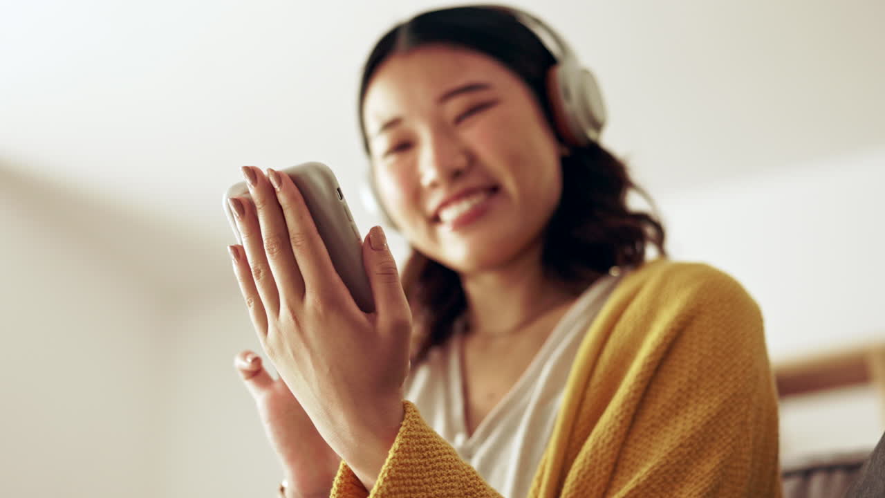 여자 손, 헤드폰과 휴대폰이 거실에 있습니다.