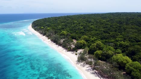 scenic static aerial landscape view of jaco island in timor-leste with idyllic turquoise crystal clear ocean water, white sandy beach, and forest