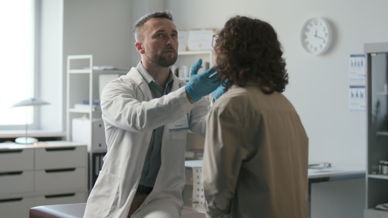 Doctor Checking Throat of Female Patient during Medical Examination