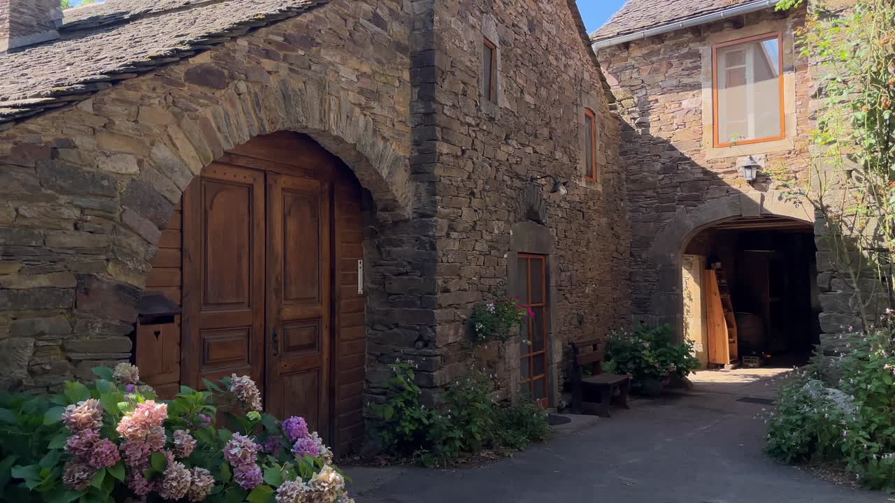 la luce del sole brilla sulla casa di pietra, e fiori di ortensia stanno fiorendo davanti alla porta