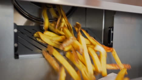 french fries falling out of the fryer in slow motion