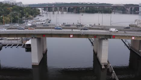 Cars,-cyclists-and-pedestrians-going-over-canal-during-rush-hour-on-bridge-in-Södermalm,-Stockholm,-Sweden-during-cloudy-evening