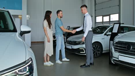 una pareja feliz compra un coche.