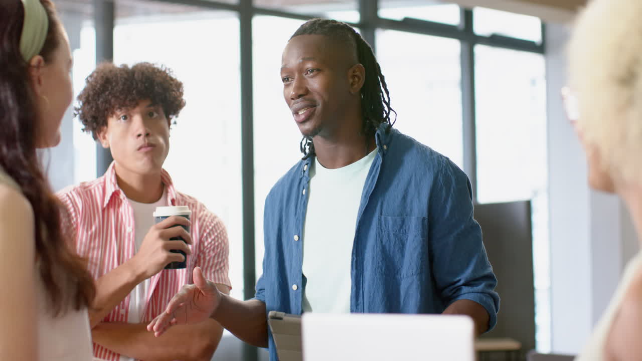 Discussing project, diverse team collaborating with tablet and coffee in office