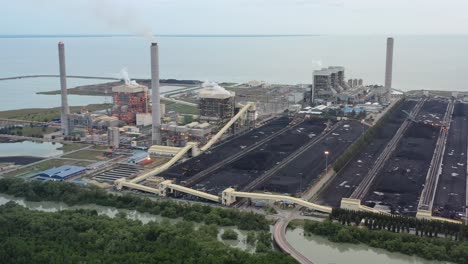 campo de carbón costero y planta de energía de carbón ultrasupercrítica industrial con humo saliendo de la chimenea ubicada en la terminal a granel de lekir jalan, teluk rubiah, manjung, perak, malasia