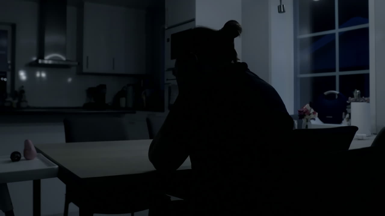 una mujer triste y deprimida se sienta en la mesa de la cocina en casa despierta por la noche