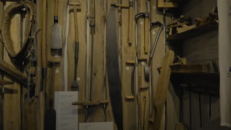 Old-Hand-Tools-Hanging-On-A-Wall-In-A-Vintage-Shop-In-Swornegacie,-Northern-Poland---Closeup-Pan-Left