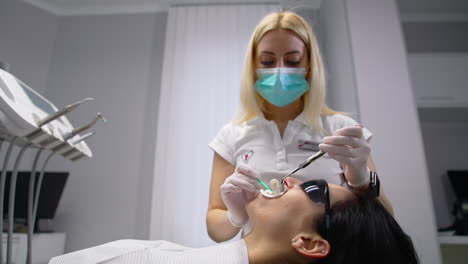 stomatologist and patient at clinical office. patient getting dental treatment at dental office
