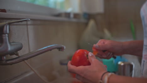 Nahaufnahmen-Einer-Frau,-Die-Zu-Hause-Eine-Tomate-Schält