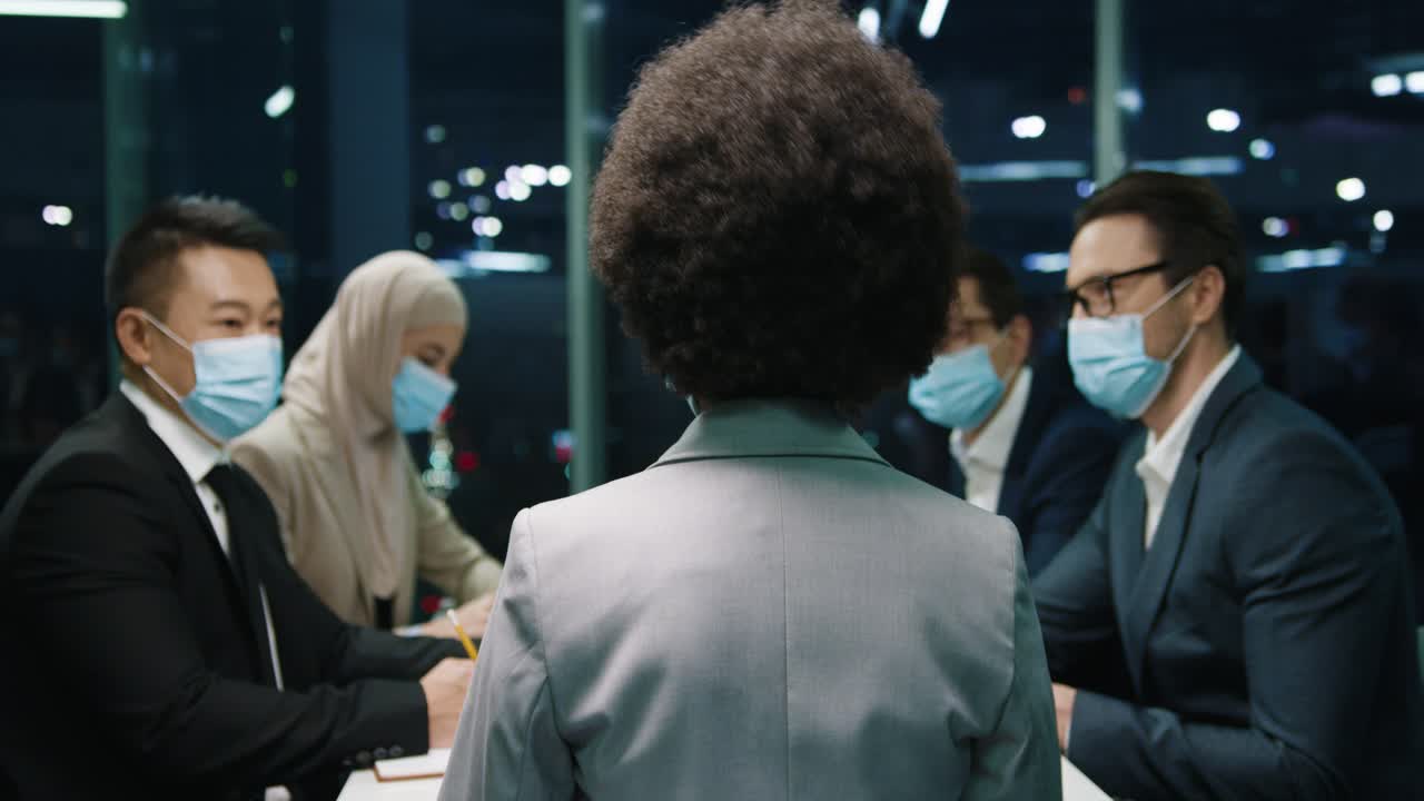 вид сзади на бизнесмена, разговаривающего со своей командой на совещании в офисе 1