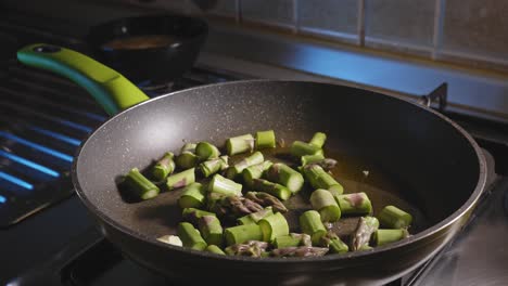 sauteing chopped asparagus in a pan with oil