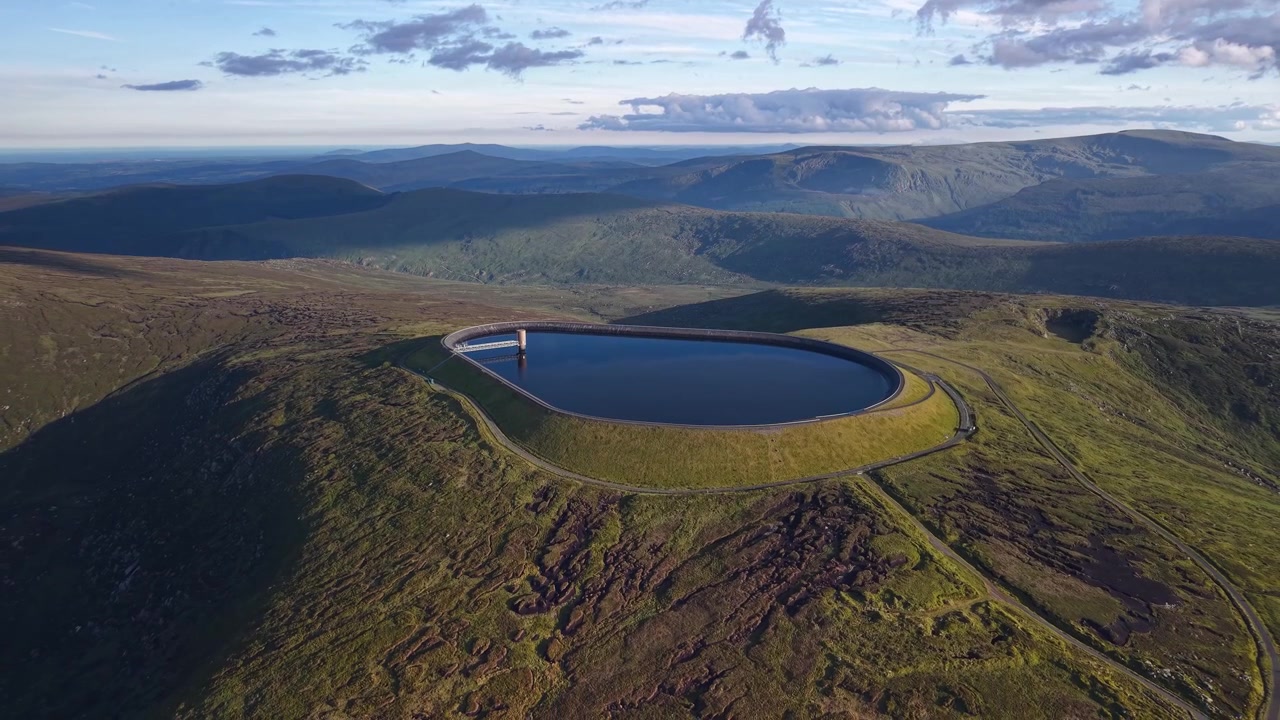 Splendida ripresa aerea in allontanamento del serbatoio idrico di Turlough Hill e delle montagne di Wicklow all'ora d'oro.