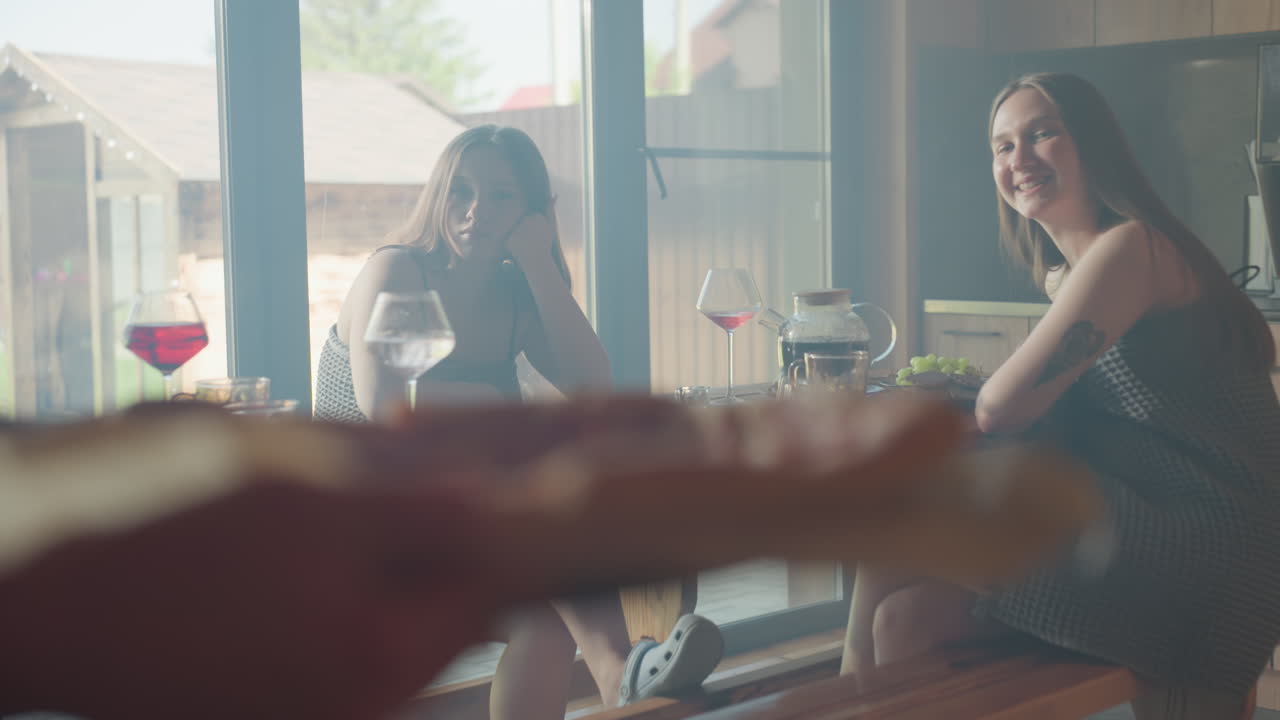 Beautiful moment with colleagues having a good time together, smiling and enjoying conversation over pizza, cozy indoor setting, sunlight streaming in through windows