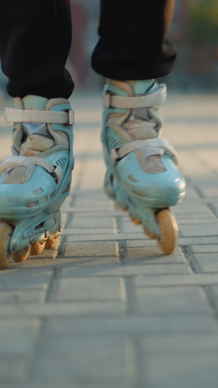A close-up view of a person s feet wearing rollerblades, gliding on a paved path in a park. The focus on the rollerblades emphasizes the motion and activity, with the background softly blurred
